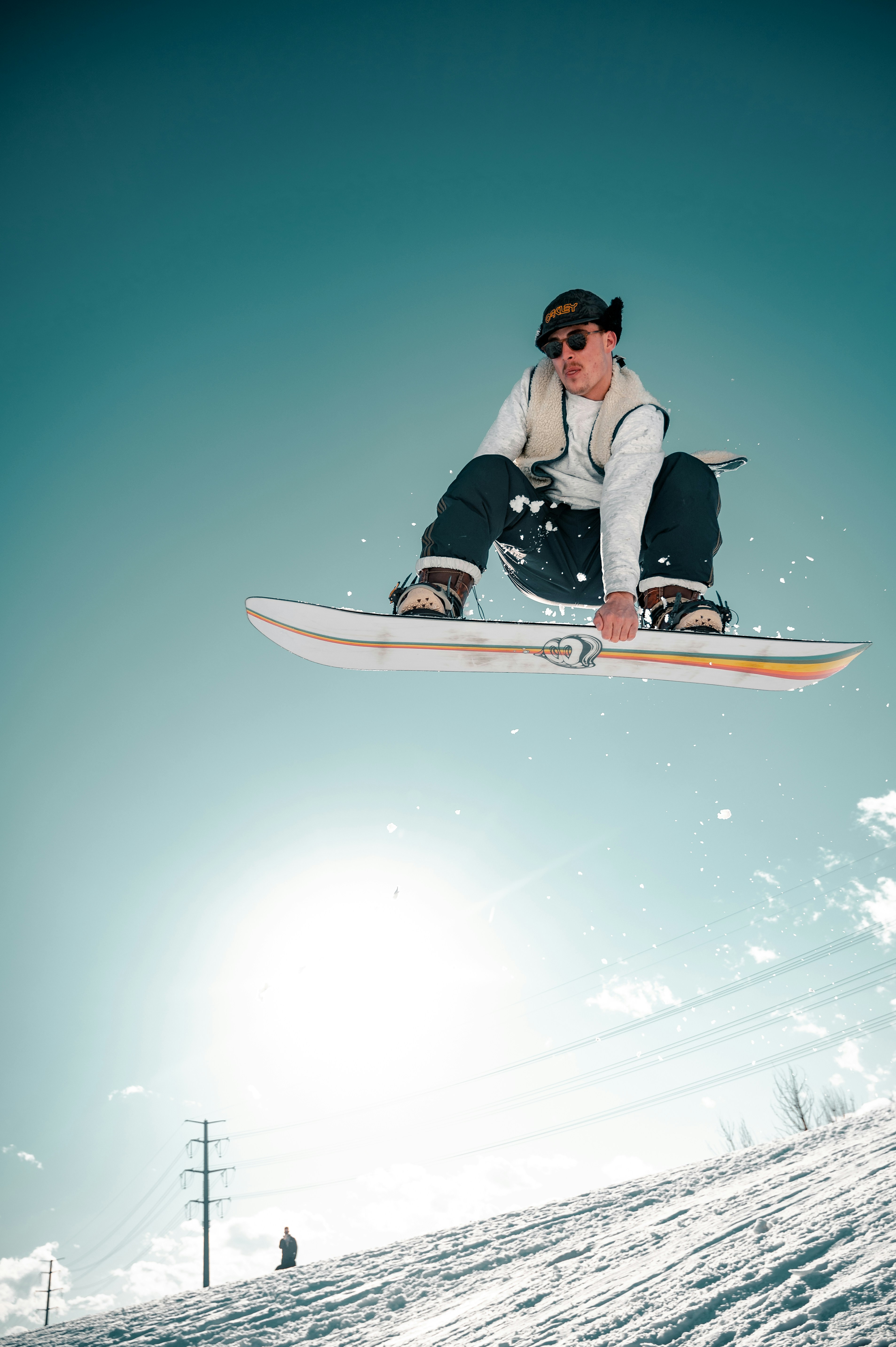 The alt text for the image is: Man riding a snowboard in the air on a snowy slope.